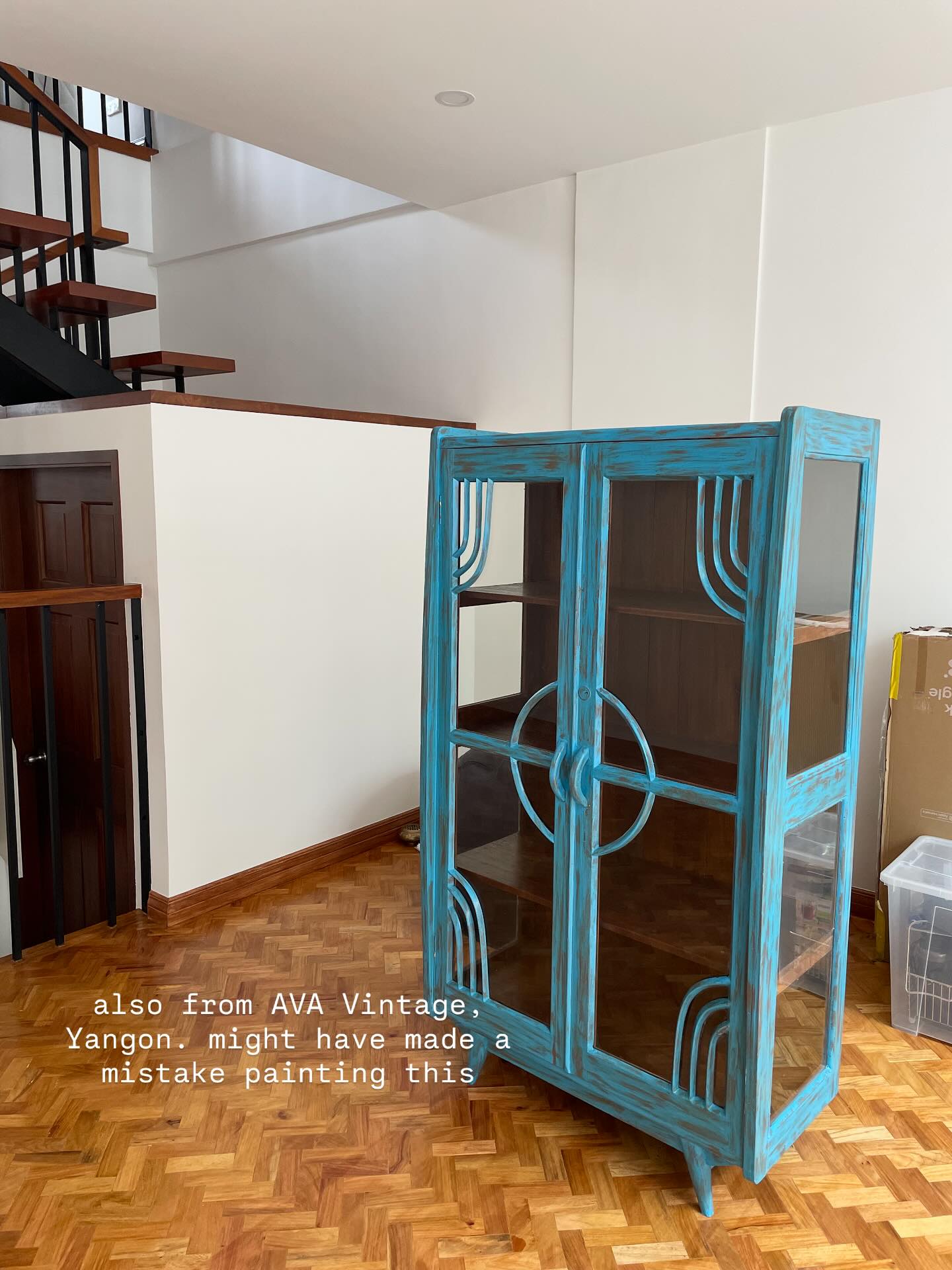 Blue vintage display cabinet with glass doors in a home interior