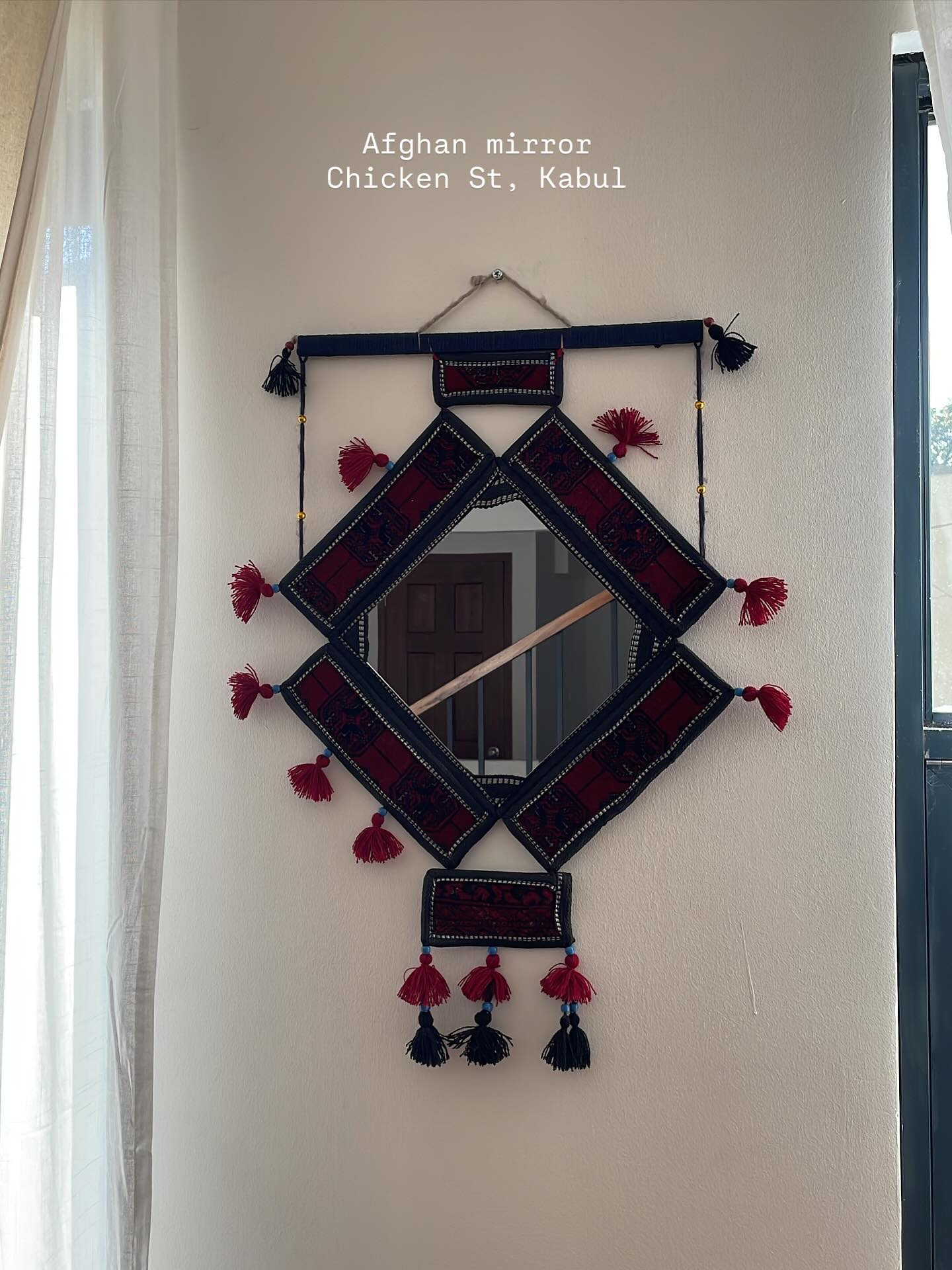 Handwoven textile wall hanging with tassel details
