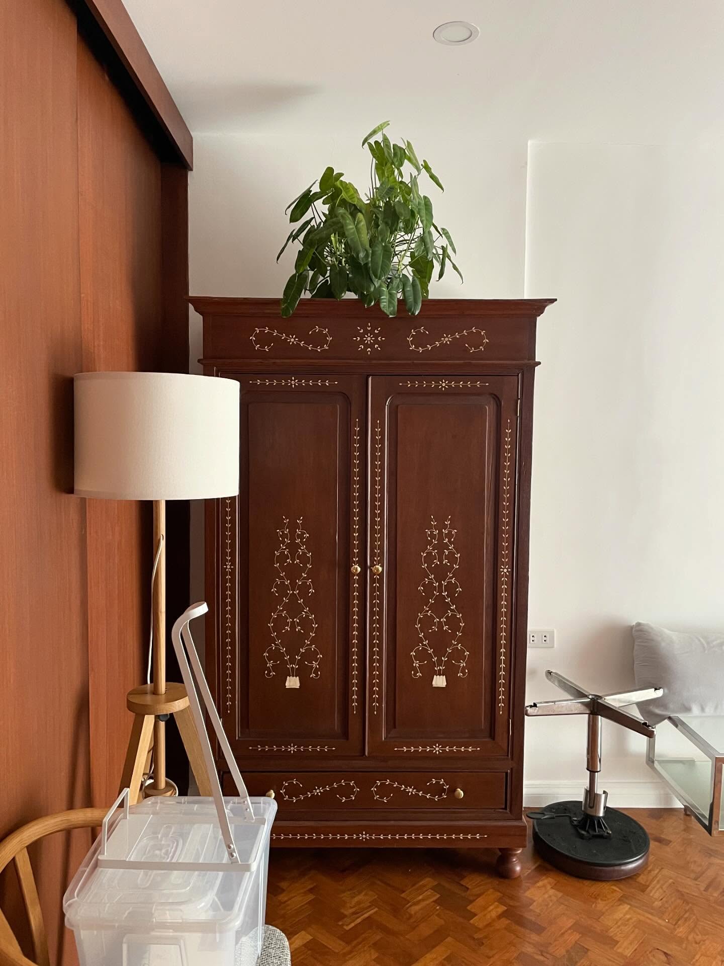 Tall carved antique wood cabinet in a home interior